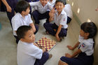 Vietnames schoolkids playing chest. Vietnamesische Schulkinder spielen Schach in der Pause