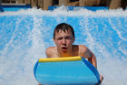 Young boy surfing in the water channel, basin of the luxury five star hotel RIXOS in Belek, Antalya, Turkey. Fun, water-sport, holiday, Junger Knabe surft im Wasserkanal des Luxus-Hotels RIXOS an der türkischen Riviera in Belek bei Antalya. 