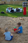 So lässt sich das Fussballfan-Leben in villen Zügen geniessen. Mama und Papa auf dem aufblasbaren Sitzkissen relaxend und zwischendurch auf die Monitore schauend, die Kinder spielen im Sandkasten davor