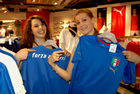 Zwei Frauen mustern Azzuri-Fan-Trikots im Jelmoli World of Sports. Women trying and buying Azzuri-football-T-Shirts