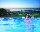 Frau im Aussen-Schwimmbad des Panorama Resort & Spa Feusisberg mit toller Sicht über den Zürichsee. Women taking a relaxing bath at the outdoorpool of the Panorama Resort & Spa Feusisberg overlooking lake Zürich