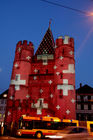 Basel, Spalentor-Illumination für die Euro 08 Fussball Spiele in Basel. Lichtkunstspektakel von Gerry Hofmann und gesponsort von der Bank Credit Suisse. Wahrzeichen von Basel mit Schweizer Kreuzen geschmückt beleuchtet