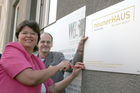 StadtrŠtin Renate Brauner (Gesundheit und Soziales) und Hannes Lorenz (Hausleiter) befestigen die Tafel. Das neunerHAUS bietet Menschen in akuter Wohnungslosigkeit Unterschlupf.