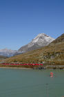 Der Bernina-Express auf seiner Fahrt durchs Unesco Weltkulturerbe beim Lago Bianco auf dem Bernina Hospitz. Bernina-Express mountain train driving through the Unesco world heritage at Lago Bianco on Bernina-Hospitz