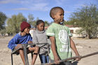 Namibische Kinder beim Spiel und Nachahmung eines Pferde- oder Eselgespanns. Namibi children playing horses and donkey. 