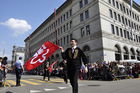 Fahnenschwinger vor dem Zürcher Nationalbank-Gebäude am Sechseläuten-Umzug. 