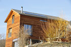 Ein modernes Bündner Holzhaus, dass sich gut in die Natur und den Dorfkern von Scharans integriert und selbst mit Sonnenkollektoren Strom produziert.