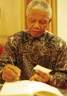 Friedensnobelpreisträger Nelson Mandela signiert, als neuer Präsident Südafrikas, im Dolder Hotel in Zürich vor der Schweizer Hochfinanz sein Buch. 