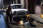 Ein Kubaner wäscht seinen Oldtimerl in Havanna. Seine Tochter hilft ihm dabei. Ohne fließend Wasser gar nicht so einfach. A cuban men is washing his oldtimer in HAvanna vjeja. But without current water not so easy.