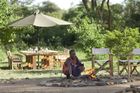 Ein Masaai entfacht ein Lagerfeuer im Mara Porini Camp für die Safari-Gäste im Masaai-Land