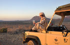 Genus pur in der Wildnis. Eine Touristin geniesst den Sonnenuntergang im Samburu Nationalpark mit einem Glass Champagner. Enjoying a sundowner champagne glass in the wilderness of Samburu Nationalpark 