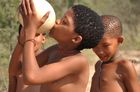 Ein Mädchen einer Naro-San Bushmen Gruppe trinkt aus dem Straussenei, dass zuvor im Wüstenboden der Kalahari vergraben war