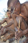 Bushmen makes fire with the wooden-sticks. mit den Feuer-Hölzern am Werk